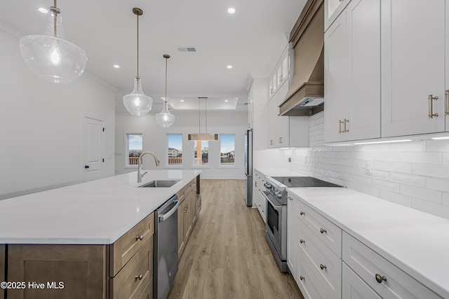 kitchen featuring a sink, visible vents, appliances with stainless steel finishes, backsplash, and light wood finished floors