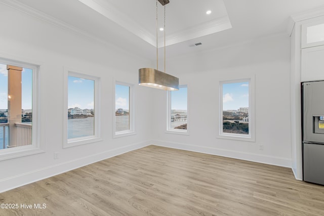 unfurnished dining area with baseboards, a tray ceiling, crown molding, light wood-type flooring, and recessed lighting