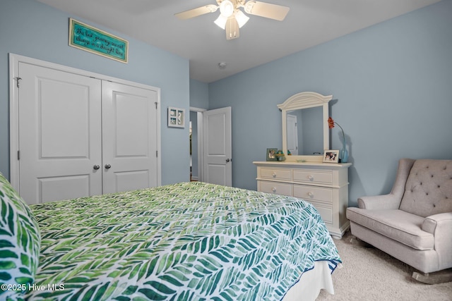 bedroom with a ceiling fan, a closet, and light carpet