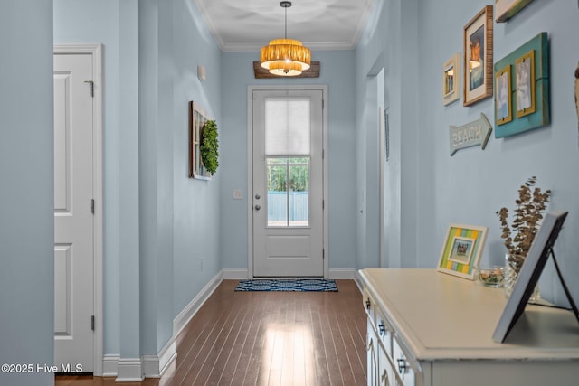 entryway with dark wood-style floors, ornamental molding, and baseboards