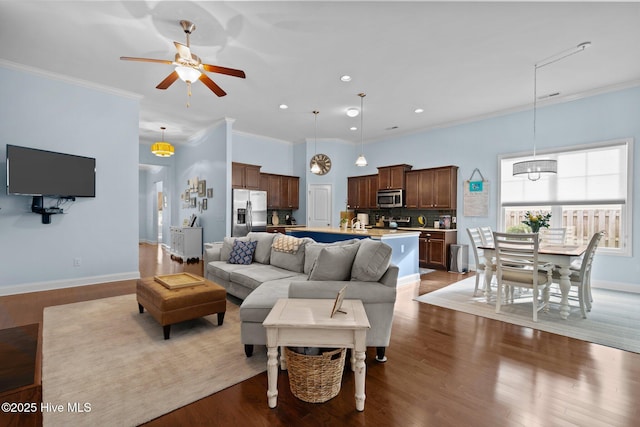 living room with recessed lighting, crown molding, baseboards, and wood finished floors