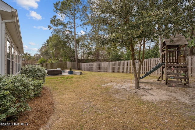 view of yard with an outdoor living space, a playground, and a fenced backyard