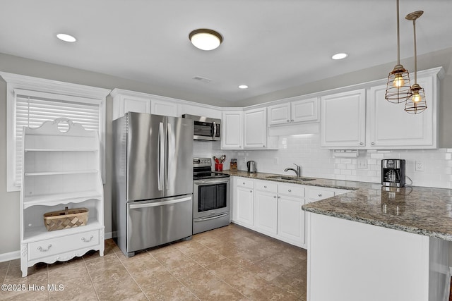 kitchen with stainless steel appliances, white cabinetry, a sink, and a peninsula