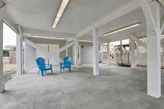 view of patio / terrace featuring a carport, fence, and stairway