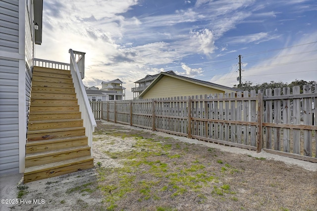 view of yard with fence and stairway