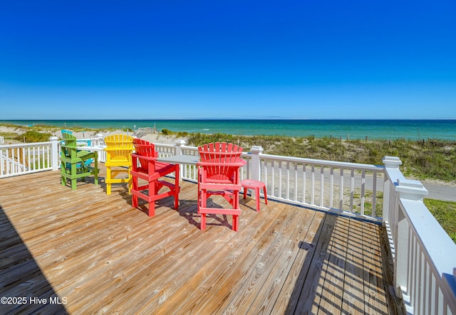 wooden terrace with a water view and a view of the beach