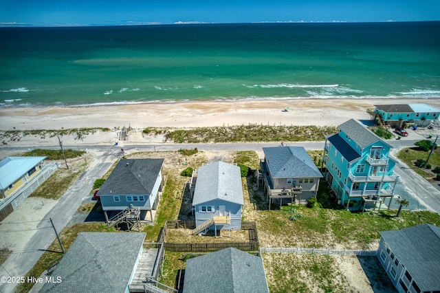 drone / aerial view featuring a water view and a beach view