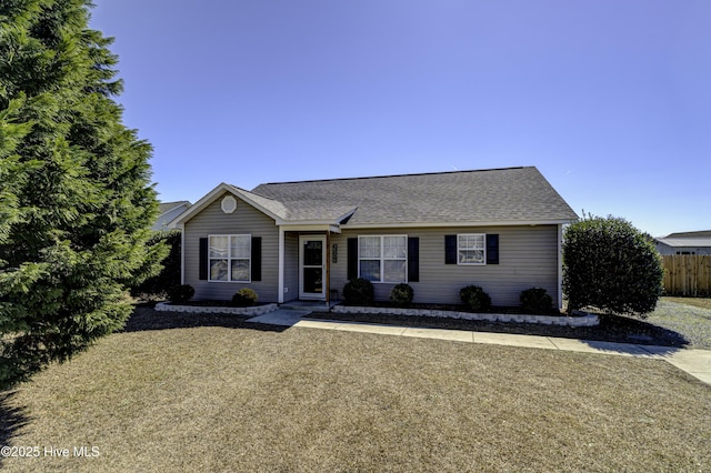 single story home with a shingled roof and fence