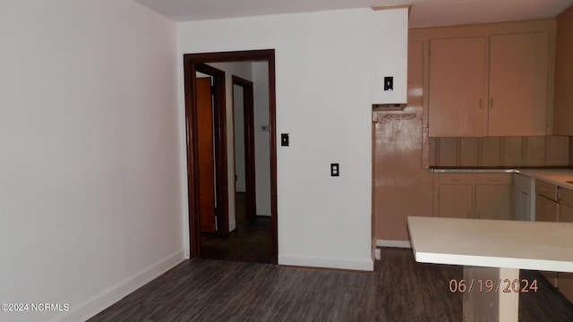 kitchen featuring baseboards, backsplash, dark wood-style flooring, and light countertops