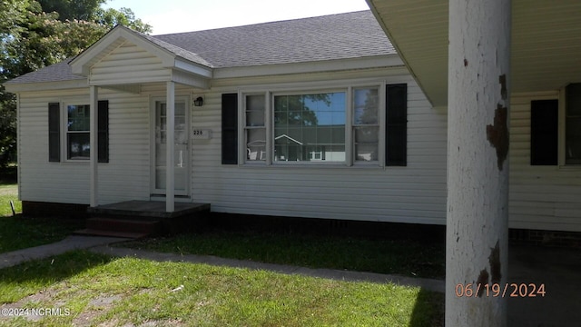 view of front facade with roof with shingles