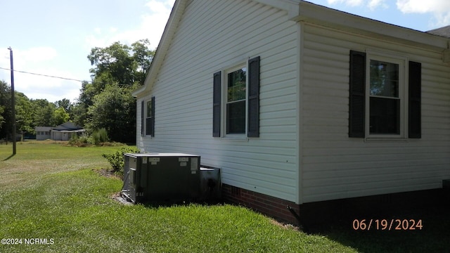 view of home's exterior with central AC and a lawn