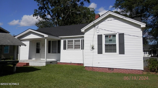 back of property with a yard and crawl space