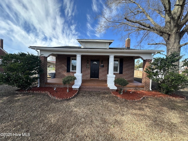 bungalow-style home featuring brick siding and a porch