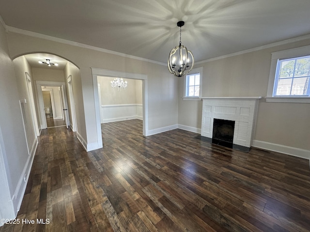 unfurnished living room featuring dark wood finished floors, a fireplace, baseboards, and arched walkways