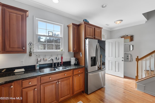 kitchen featuring a sink, stainless steel fridge with ice dispenser, ornamental molding, light wood-type flooring, and brown cabinets