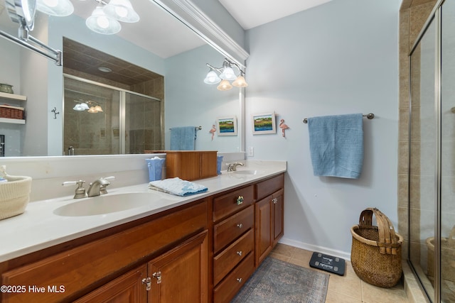 bathroom featuring double vanity, a stall shower, tile patterned flooring, and a sink