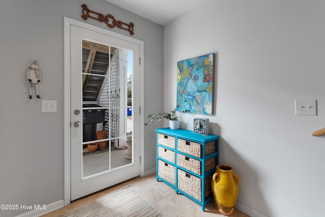 doorway featuring tile patterned flooring and baseboards