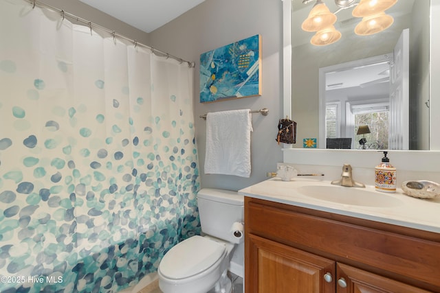 full bathroom featuring a shower with shower curtain, vanity, and toilet