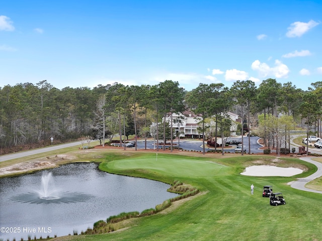 view of property's community with view of golf course and a water view