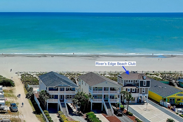 drone / aerial view featuring a residential view, a water view, and a beach view