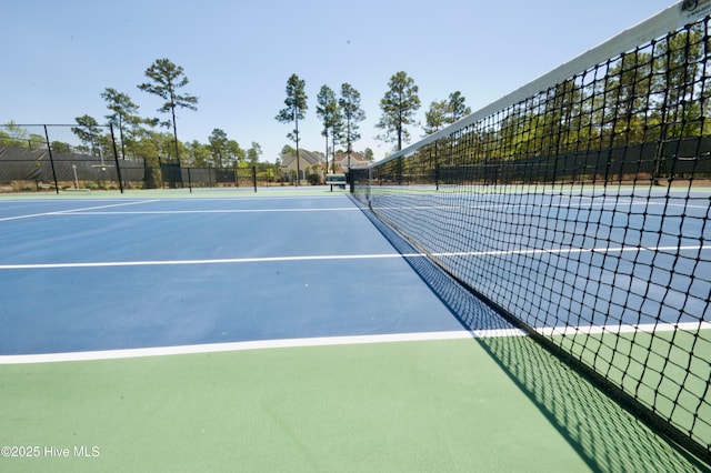 view of tennis court featuring fence