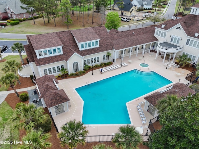 view of pool with a patio, a community hot tub, a fenced in pool, and a fenced backyard
