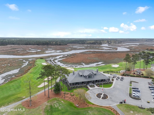 drone / aerial view with view of golf course and a water view