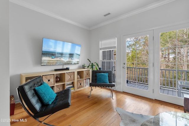 sitting room with ornamental molding, wood finished floors, and visible vents