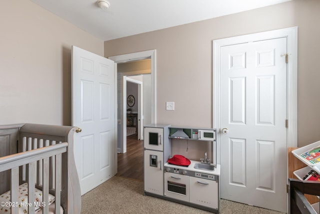 bedroom with light carpet and a crib