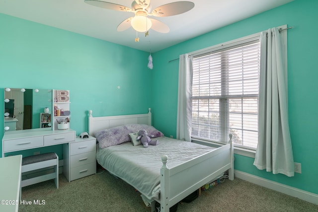 carpeted bedroom with ceiling fan and baseboards