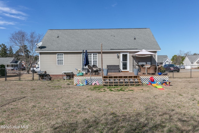 back of property with a gate, a lawn, a deck, and fence