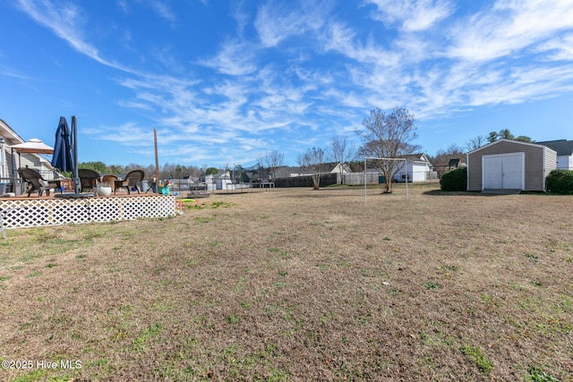 view of yard featuring a shed, an outdoor structure, and fence