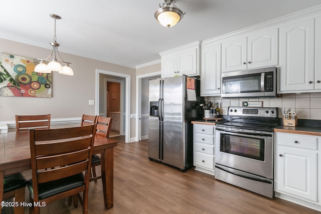 kitchen with appliances with stainless steel finishes, dark wood-style floors, crown molding, and white cabinetry