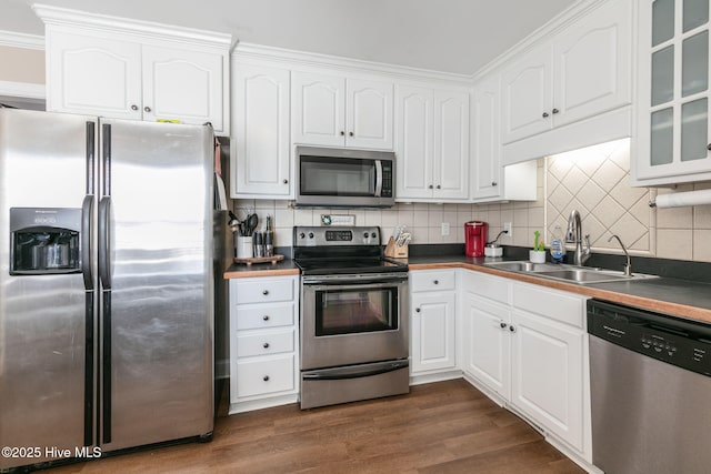 kitchen with a sink, stainless steel appliances, and white cabinetry