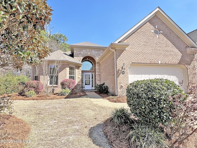 view of front of house with an attached garage and brick siding