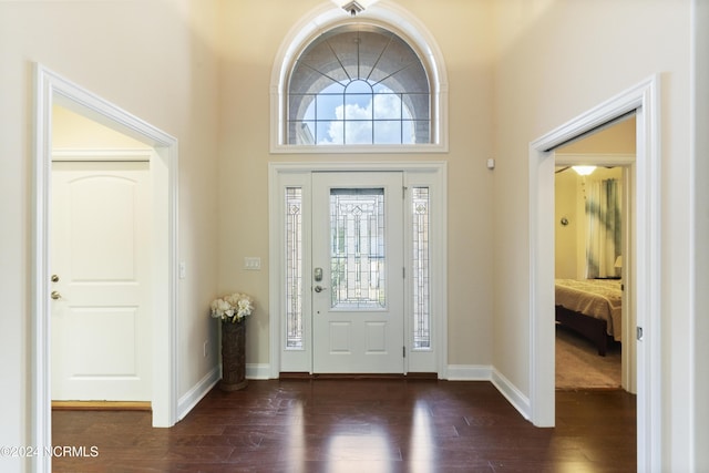 foyer with dark wood-type flooring and baseboards