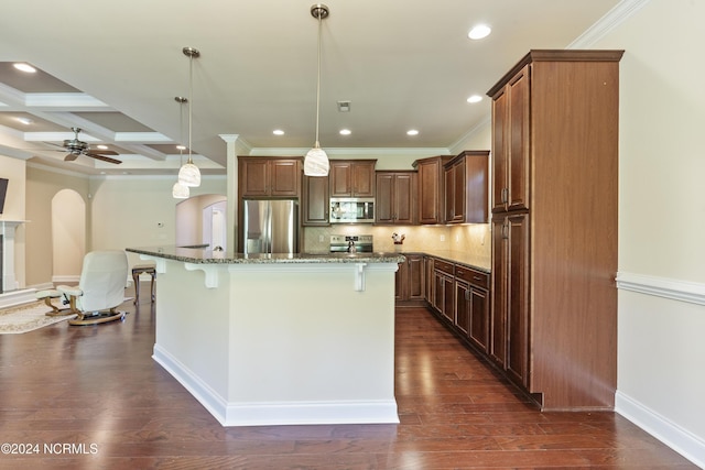 kitchen featuring backsplash, dark stone countertops, appliances with stainless steel finishes, arched walkways, and a ceiling fan