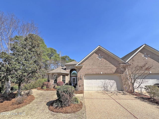 view of front of house featuring a garage, brick siding, and driveway