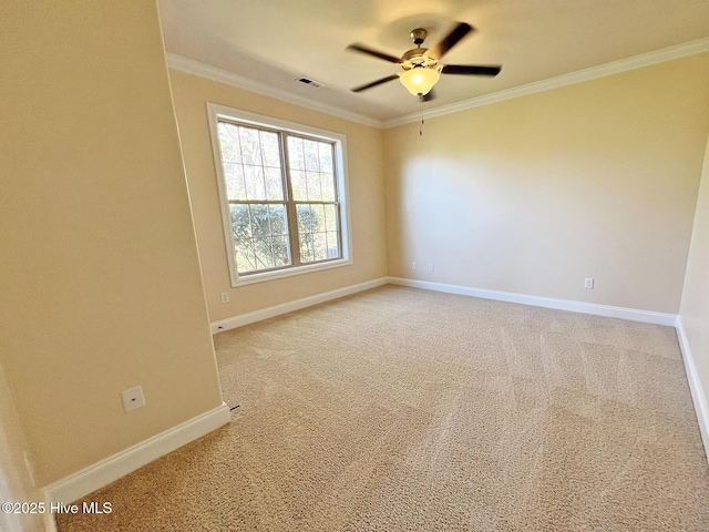 empty room with a ceiling fan, visible vents, baseboards, crown molding, and light colored carpet