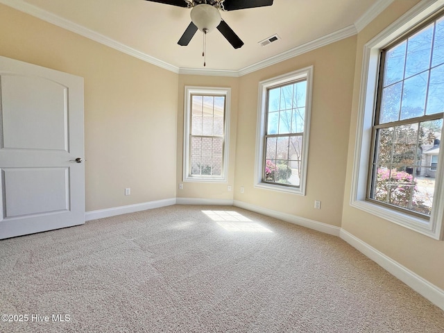 carpeted empty room with crown molding, baseboards, visible vents, and ceiling fan