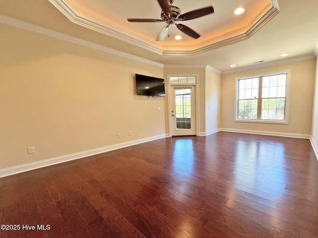 spare room with a raised ceiling, crown molding, dark wood-type flooring, and ceiling fan