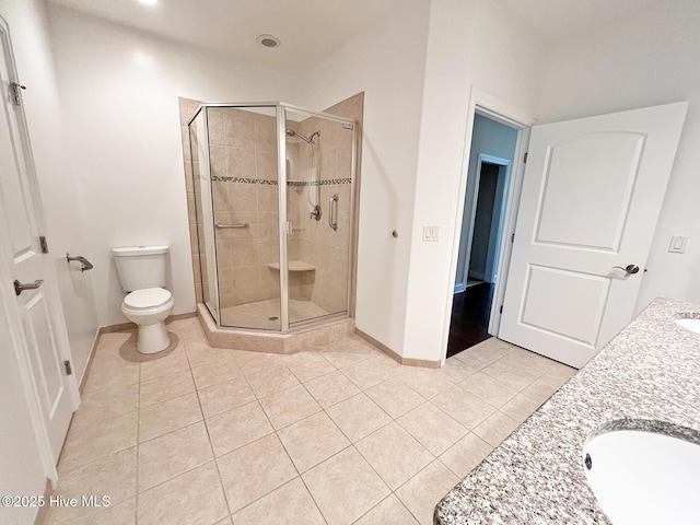 full bath with tile patterned floors, toilet, a stall shower, and a sink