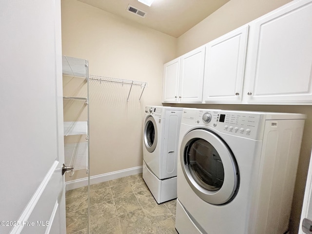 clothes washing area featuring baseboards, visible vents, cabinet space, and independent washer and dryer