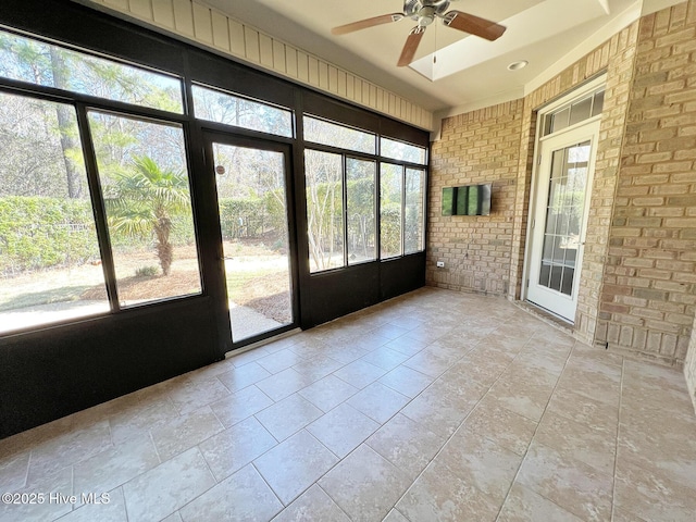 unfurnished sunroom with ceiling fan