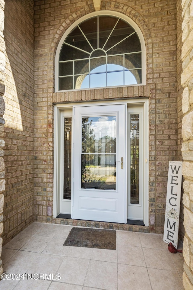 entrance to property featuring brick siding