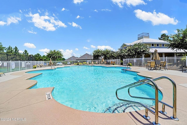 community pool featuring a patio and fence