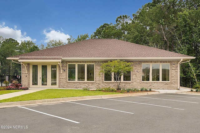 rear view of property with uncovered parking and brick siding