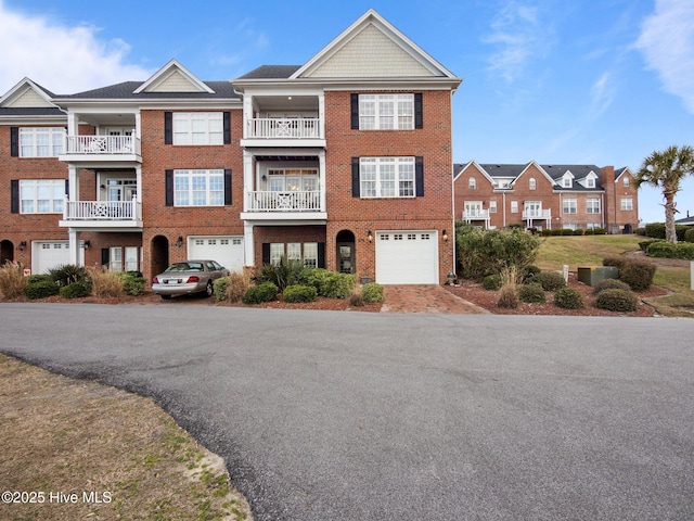 view of front of property featuring brick siding, driveway, and an attached garage