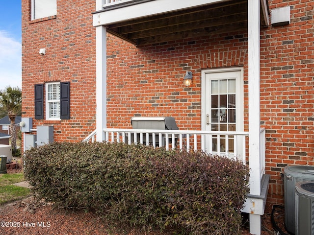 view of side of home with central AC unit and brick siding