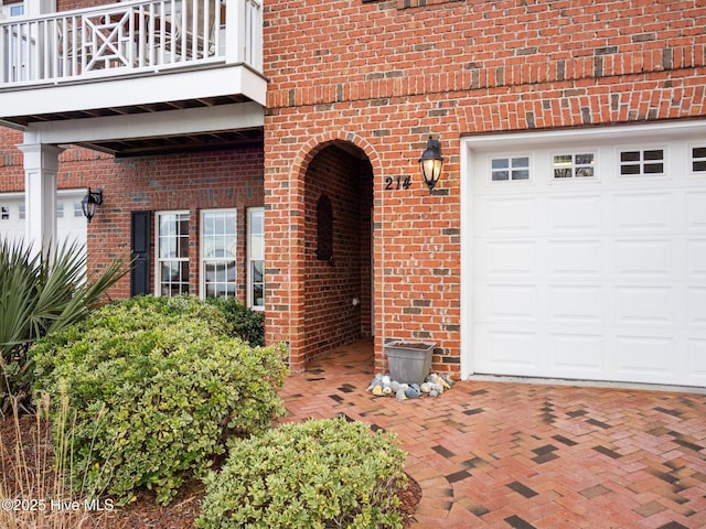 property entrance with brick siding and a balcony